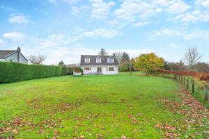 a large grassy yard with a white house at 3 Bed in North Connel oc-a29963 in Connel