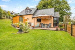 a house with a backyard with a table and an umbrella at 2 Bed in Devils Bridge oc-d29575 in Devils Bridge