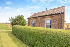 a brick house with a hedge in front of it at 1 Bed in Toynton All Saints oc-s29840 in Toynton All Saints
