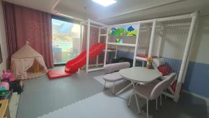 a childs room with a table and chairs and a window at Geoje Theview Kids Poolvilla in Geoje +42 photos