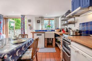 a kitchen with a counter and a table with chairs at 2 Bed in Corfe Castle oc-a30970 in Corfe Castle +14 photos