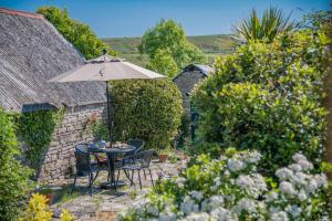 a table and chairs with an umbrella in a garden at 2 Bed in Corfe Castle oc-a30970 in Corfe Castle