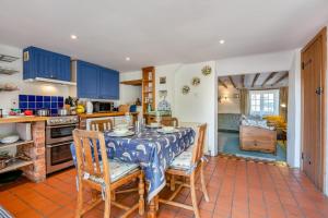 a kitchen with a table and chairs and blue cabinets at 2 Bed in Corfe Castle oc-a30970 in Corfe Castle