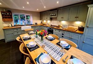 a kitchen with a wooden table with plates and flowers at 4 Bed in Little Hayfield oc-c31097 in Hayfield