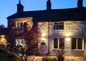 a white brick house with lights on it at 4 Bed in Little Hayfield oc-c31097 in Hayfield