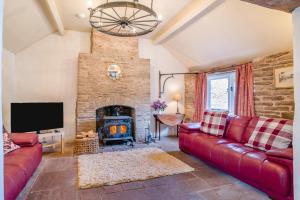 a living room with a red couch and a fireplace at 3 Bed in Llanvetherine oc-g31918 in Llanvetherine