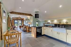 a large kitchen with white cabinets and a table at 1 Bed in Saltfleetby oc-b30073 in Saltfleetby Saint Peter