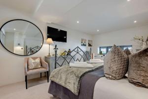 a bedroom with a bed with a mirror and a chair at 5 Bed in St. Issey oc-r4328 in Saint Issey