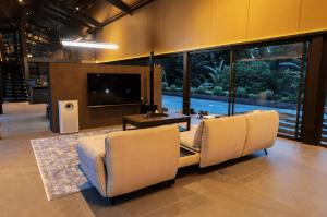 a living room with two chairs and a television at Spring River Cisarua in Paragajen