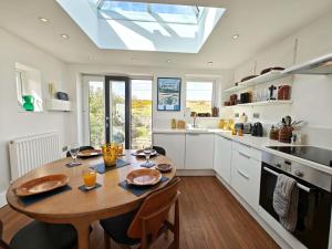 a kitchen with a wooden table and a kitchen with a skylight at 2 Bed in Craster oc-c25099 in Craster