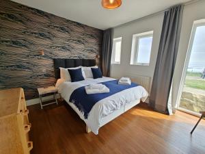 a bedroom with a bed with a large wall at 2 Bed in Craster oc-c25099 in Craster