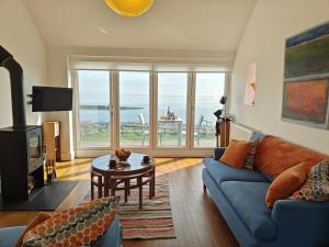 a living room with a blue couch and a table at 2 Bed in Craster oc-c25099 in Craster
