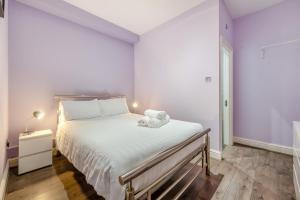 a bedroom with a large bed with white sheets at 1 Bed in Tenby oc-w28984 in Tenby