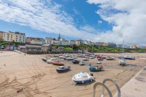 a group of boats sitting on the sand on a beach at 1 Bed in Tenby oc-w28984 in Tenby
