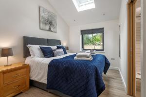a bedroom with a bed with a blue comforter and a window at 4 Bed in Saham Toney oc-o30348 in Saham Toney