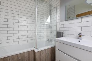 a white bathroom with a tub and a sink at 4 Bed in Saham Toney oc-o30348 in Saham Toney +22 photos