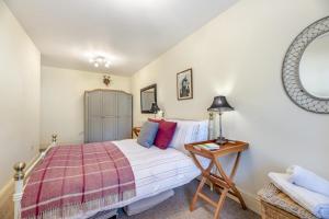 a bedroom with a bed and a table and a mirror at 2 Bed in Cornhill-on-Tweed oc-d30765 in Cornhill-on-tweed