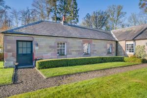an old brick house with a blue door and a yard at 2 Bed in Cornhill-on-Tweed oc-d30765 in Cornhill-on-tweed