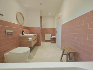 a bathroom with a toilet and a sink and a tub at 5 Bed in Tealby oc-t30618 in Tealby +22 photos