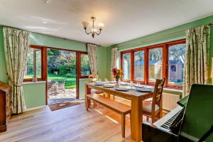 a dining room with a table and a piano at 5 Bed in Dymchurch oc-w30161 in Dymchurch