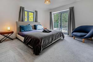 a bedroom with a bed and a blue chair at 4 Bed in Wadebridge oc-l30127 in Wadebridge