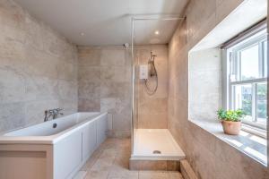 a bathroom with a bath tub and a window at 4 Bed in St. Brides oc-o30488 in Saint Brides +25 photos