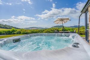 a hot tub with an umbrella in a yard at 3 Bed in Newburgh oc-h32592 in Newburgh