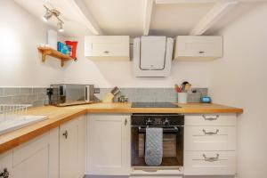 a kitchen with white cabinets and a stove at 2 Bed in Kirkcudbright oc-a30803 in Kirkcudbright +11 photos