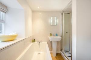 a white bathroom with a sink and a bath tub at 2 Bed in Kirkcudbright oc-a30803 in Kirkcudbright