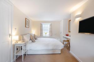 a white bedroom with a bed and a tv at 2 Bed in Kirkcudbright oc-a30803 in Kirkcudbright
