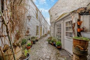 an alley with potted plants next to a building at 2 Bed in Kirkcudbright oc-a30803 in Kirkcudbright