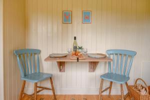 a table with two blue chairs and a bottle of wine at 1 Bed in Burnham Overy Town oc-o31908 in Burnham Market +19 photos