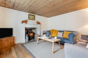 a living room with a blue couch and a table at 2 Bed in Ardgay oc-w30780 in Achnahanat