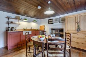 a kitchen with a table and some chairs and a kitchen with a tableablish at 2 Bed in Ardgay oc-w30780 in Achnahanat