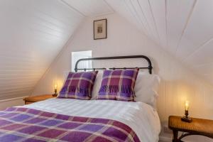 a bedroom with a bed with purple and white sheets and pillows at 2 Bed in Ardgay oc-w30780 in Achnahanat