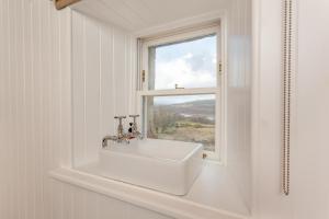 a white sink in a bathroom with a window at 2 Bed in Ardgay oc-w30780 in Achnahanat +29 photos