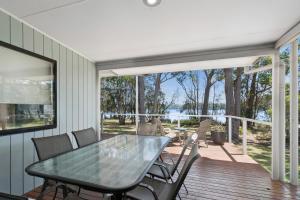 a dining room with a table and chairs on a deck at Ingenia Holidays Lake Conjola in Conjola