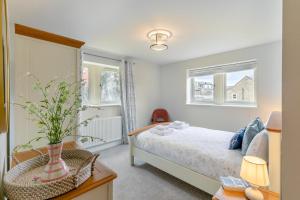 a bedroom with a bed and two windows at 4 Bed in Holmfirth oc-s31134 in Holmfirth