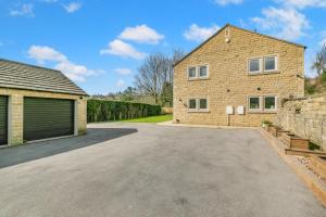 a brick house with a garage and a driveway at 4 Bed in Holmfirth oc-s31134 in Holmfirth