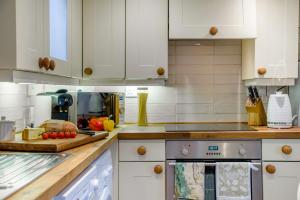 a kitchen with white cabinets and a counter top at 2 Bed in Winchcombe oc-t32023 in Winchcombe +8 photos