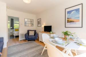 a living room with a table and chairs and a television at 2 Bed in Oxwich oc-l31089 in Oxwich +16 photos
