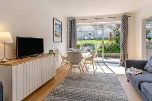 a living room with a couch and a tv and a table at 2 Bed in Oxwich oc-l31089 in Oxwich