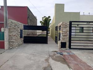 an entrance to a building with a black gate at Complejo Tres Arroyos in Tres Arroyos