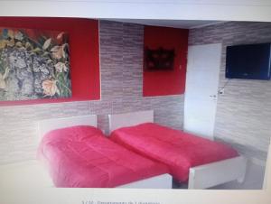 a bedroom with a bed with a red blanket at Complejo Tres Arroyos in Tres Arroyos