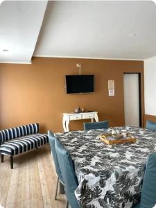 a dining room with a table and chairs and a television at Apart Vientos Sureños 2 in Yacimiento Río Turbio