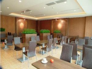 a dining room with tables and chairs and plants at Lisa Motel in Kaohsiung