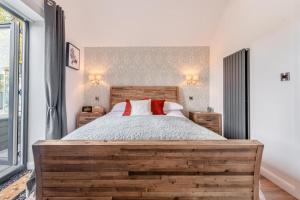 a bedroom with a wooden bed with two red pillows at 1 Bed in Hunmanby oc-w30527 in Hunmanby