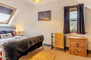 a bedroom with a bed and a dresser and windows at 2 Bed in Pentre Bach oc-b30875 in Pentre-bâch