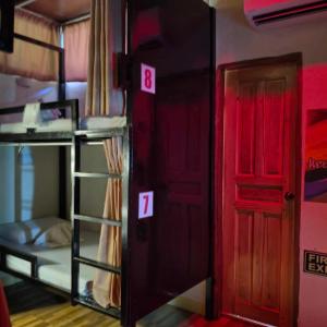 a room with two bunk beds and a red door at TAGBALAYON Lodging House in Siquijor