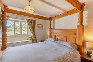 a bedroom with a wooden bed and a window at 3 Bed in Windermere oc-b31667 in Crook